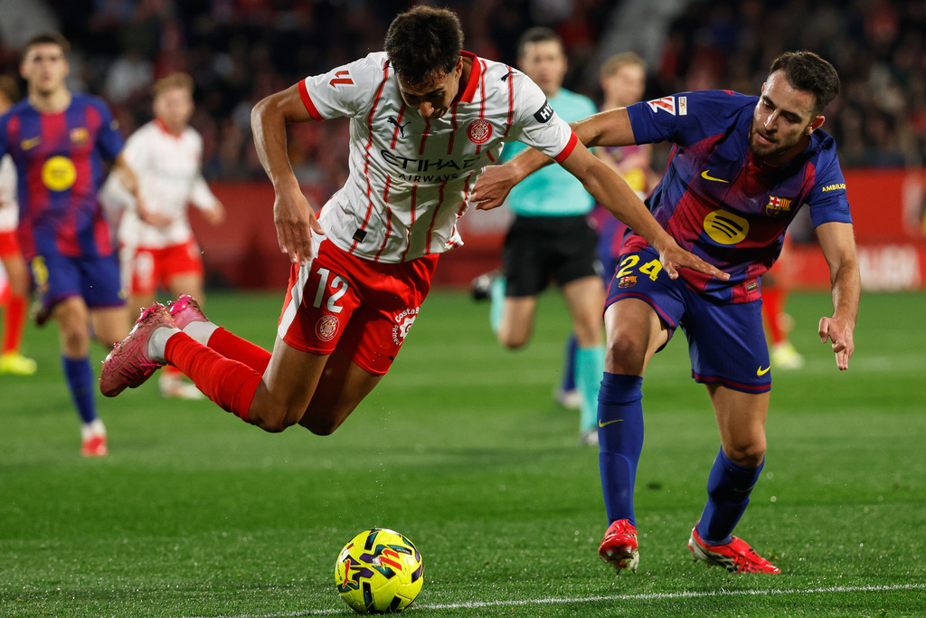 Girona's Vitor Reis is tacked by Barcelona's Eric Garcia during a Spanish La Liga soccer match between Girona and Barcelona in Girona, Spain, Monday, Feb. 16, 2026. (AP Photo/Joan Monfort)