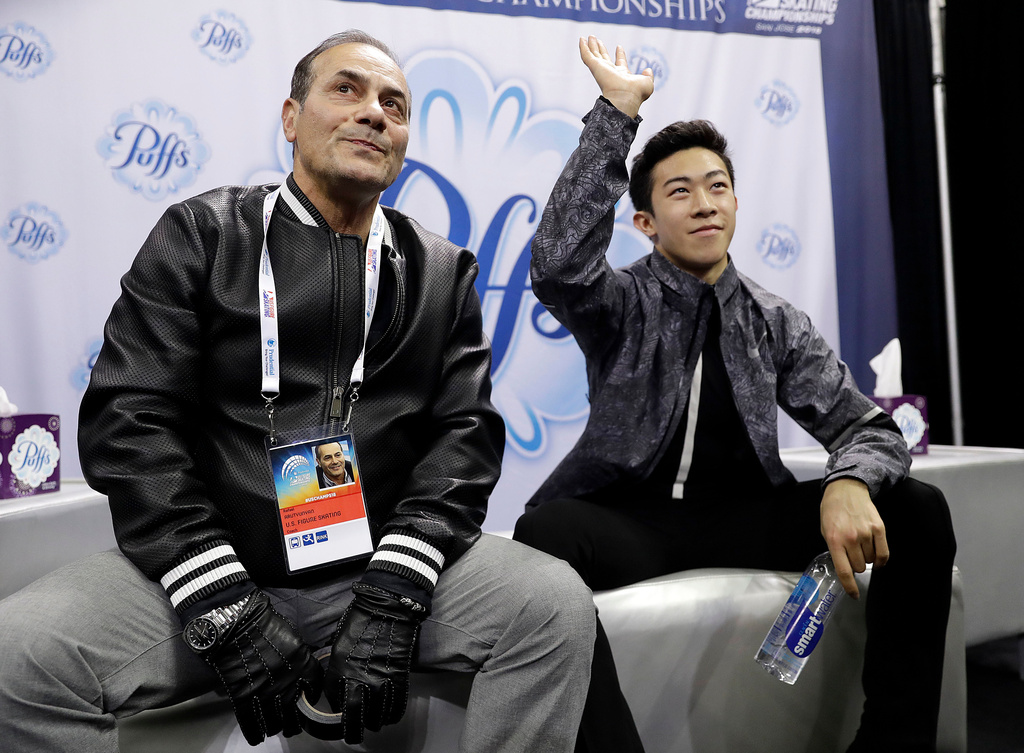 FILE - Nathan Chen, right, waves next to coach Rafael Arutyunyan after seeing his scores during the men's short program at the U.S. Figure Skating Championships in San Jose, Calif., Jan. 4, 2018. (AP Photo/Marcio Jose Sanchez, File)