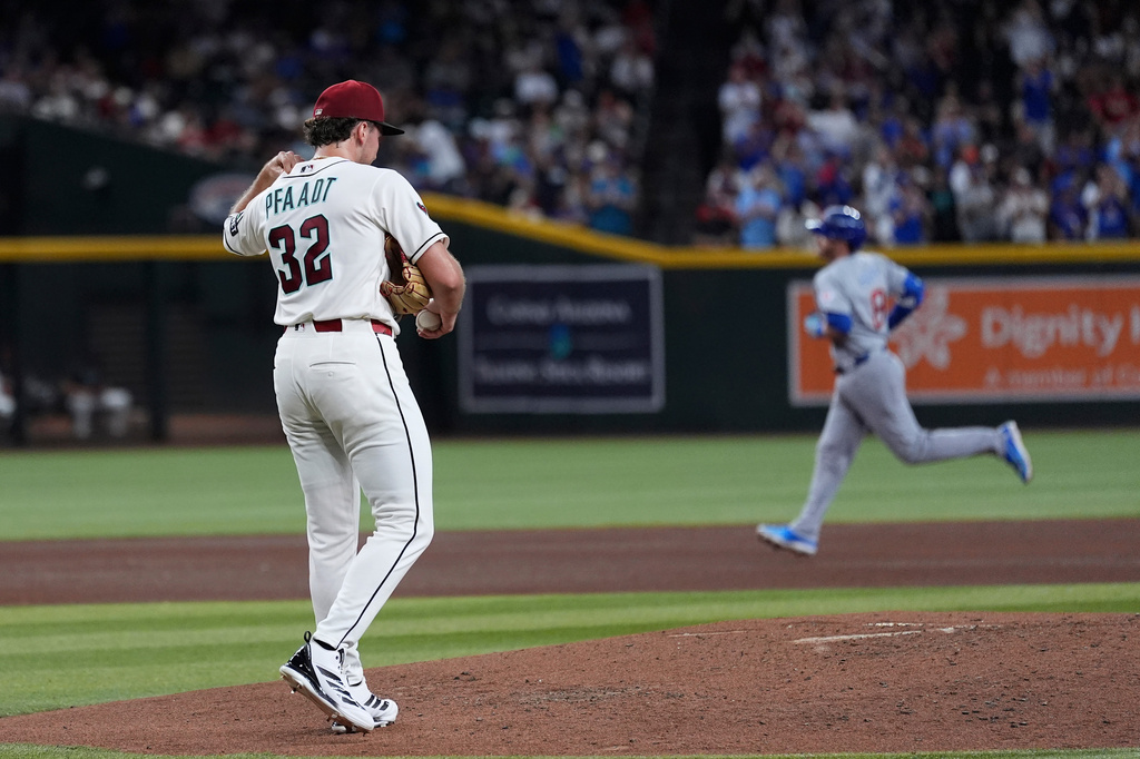 Arizona Diamondbacks starting pitcher Brandon Pfaadt (32) pauses on the pitcher's mound after giving up a three-run home run to Chicago Cubs' Ian Happ, right, during the fourth inning of a baseball game, Tuesday, Aug. 25, 2026, in Phoenix. (AP Photo/Ross D. Franklin)