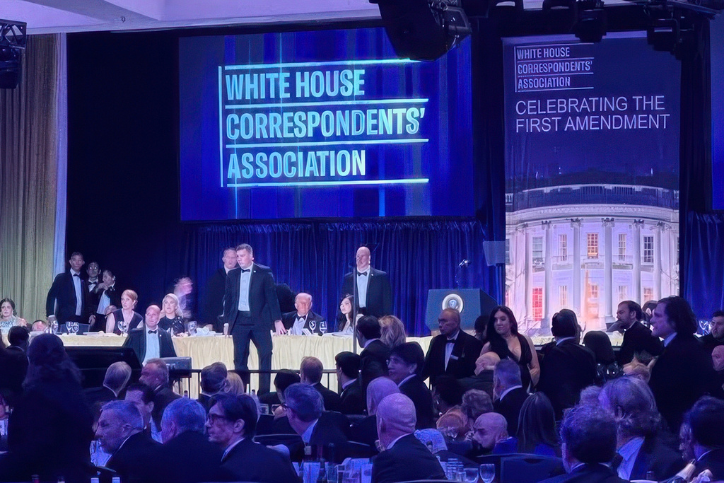 U.S. Secret Service agents surround President Donald Trump as he is taken from the stage after a shooting incident outside the ballroom during the White House Correspondents Dinner, Saturday, April 25, 2026, in Washington. (AP Photo/Alex Brandon)