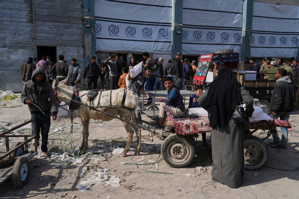 FILE - Palestinians receive bags of flour and other humanitarian aid distributed by UNRWA, the U.N. agency helping Palestinian refugees in Jabaliya, Gaza Strip, on March 25, 2025. (AP Photo/Jehad Alshrafi, File)