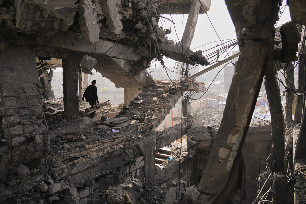 Palestinians inspect the ruins a day after an Israeli strike on a building in Gaza City, Thursday, Nov. 20, 2025. (AP Photo/Jehad Alshrafi)