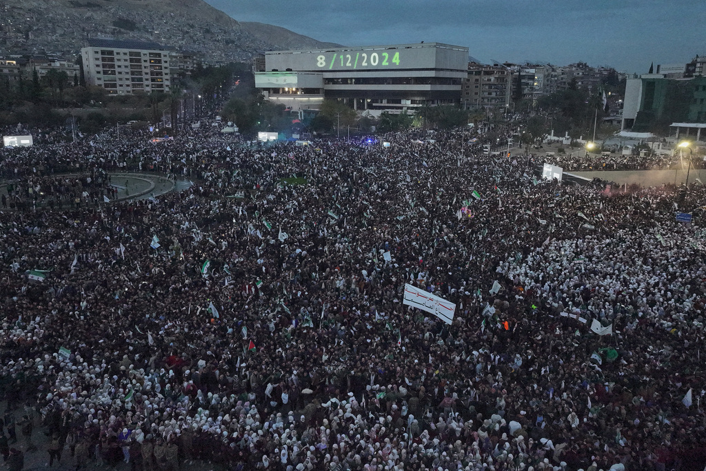 Syrian citizens gather at Umayyad square, during celebrations marking the first anniversary of the ousting of former President Bashar Assad in Damascus, Syria, Monday, Dec. 8, 2025. (AP Photo/Hussein Malla)