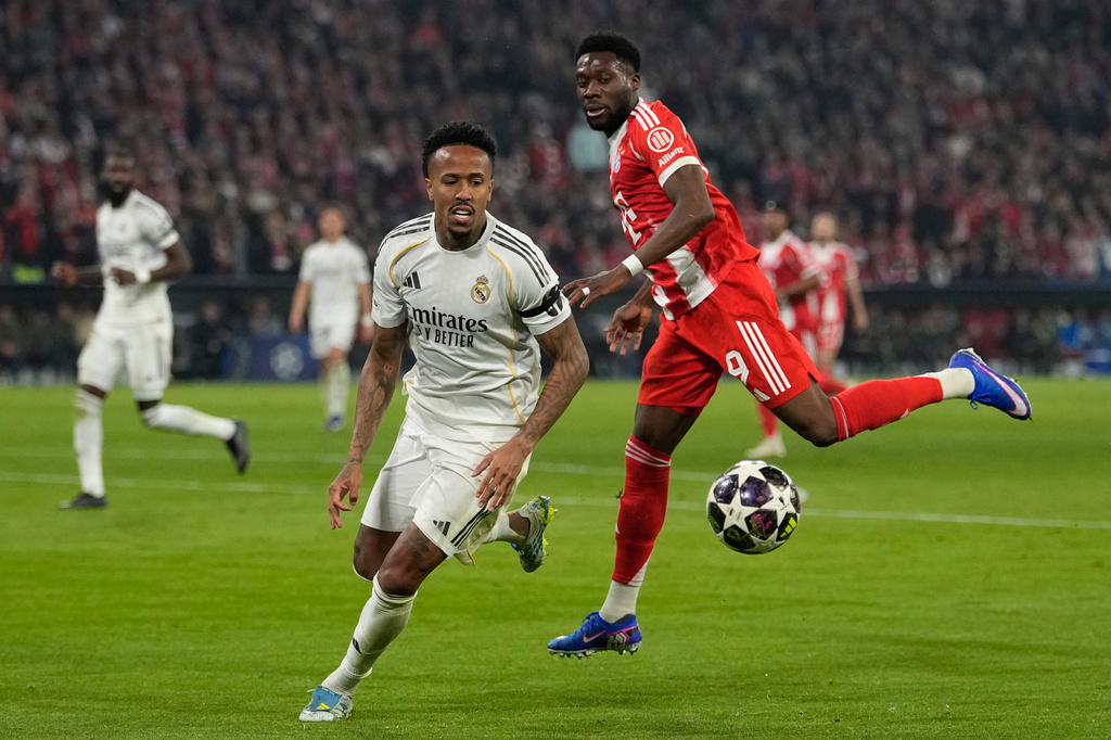 Real Madrid's Eder Militao, left, challenges for the ball with Bayern's Alphonso Davies during the Champions League quarterfinal second leg soccer match between Bayern Munich and Real Madrid in Munich, Germany, Wednesday, April 15, 2026. (AP Photo/Matthias Schrader)