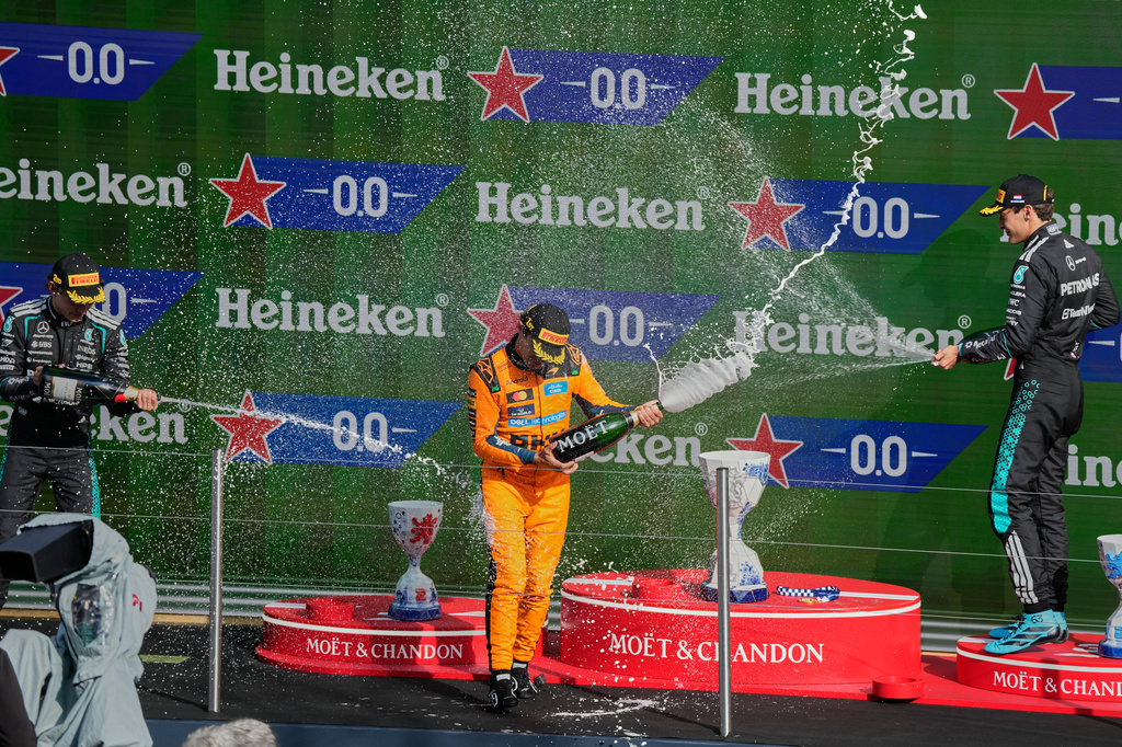From the left, second-placed Mercedes driver Andrea Kimi Antonelli of Italy, first -placed McLaren driver Lando Norris of Britain and third-placed Mercedes driver George Russell of Britain spray champagne at the podium during the Formula One Dutch Grand Prix in Zandvoort , Netherlands, Sunday, Aug. 23, 2026. (AP Photo/Darko Bandic)
