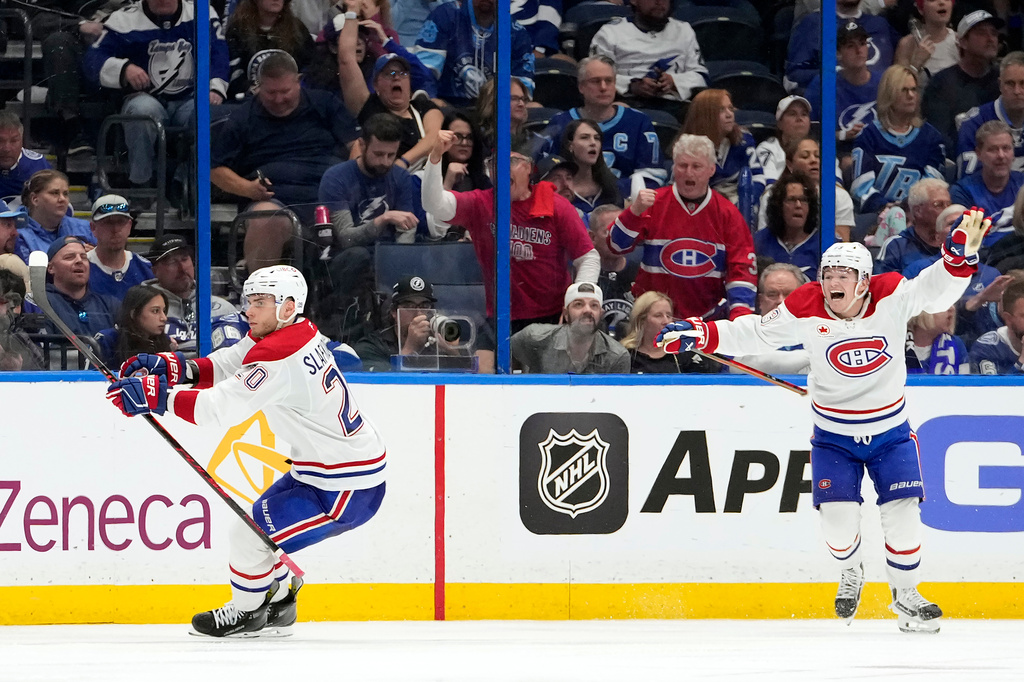 Montréal Canadiens left wing Juraj Slafkovský (20) celebrates his goal with right wing Cole Caufield against the Tampa Bay Lightning during overtime in Game 1 of an NHL hockey Stanley Cup first-round playoff series, Sunday, April 19, 2026, in Tampa, Fla. (AP Photo/Chris O'Meara)
