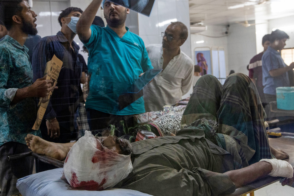 A doctor inspects an X-ray of a patient injured in an earthquake at a hospital in Dhaka, Bangladesh, Friday, Nov. 21, 2025. (AP Photo/Abdul Goni)
