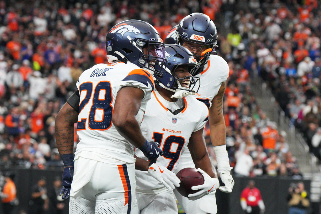 Denver Broncos' Marvin Mims Jr., middle, is congratulated by teammates after returning a punt for a touchdown against the Las Vegas Raiders during the first half of an NFL football game in Las Vegas, Sunday, Dec. 7, 2025. (AP Photo/Candice Ward)