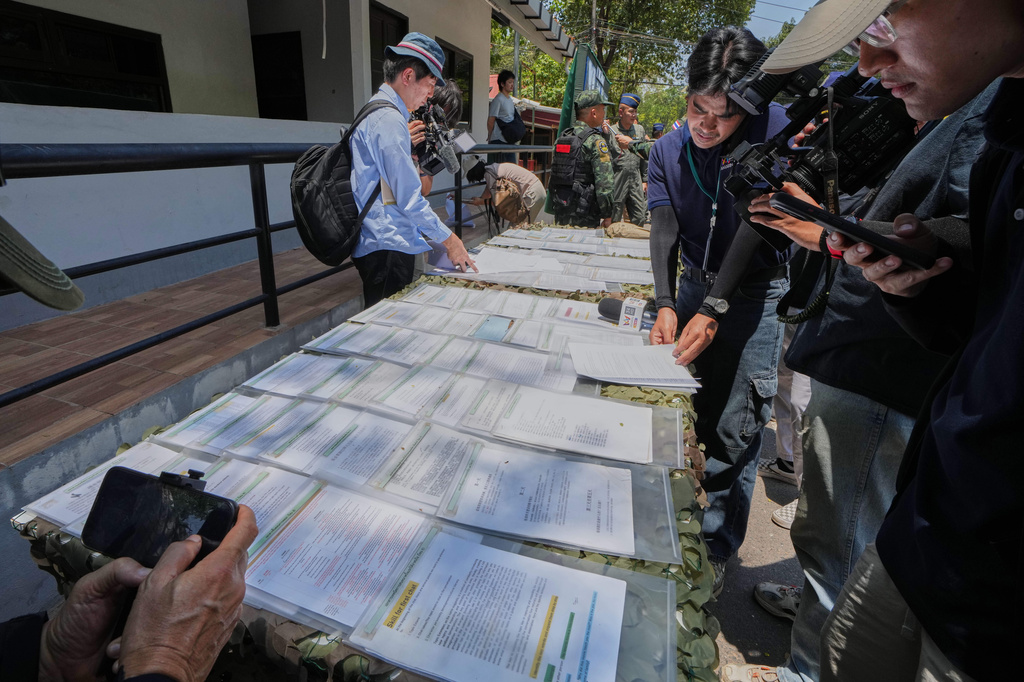 Journalist review scam scripts in Surin, Thailand, Tuesday, April 7, 2026. (AP Photo/Sakchai Lalit)
