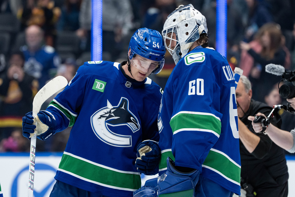 Vancouver Canucks Aatu Raty (54) and goaltender Nikita Tolopilo (60) celebrate after defeating the Minnesota Wild after third period NHL hockey game action in Vancouver, British Columbia, Saturday, Dec. 6, 2025. (Ethan Cairns/The Canadian Press via AP)