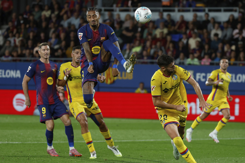 Barcelona's Raphinha jumps for the ball during a Spanish La Liga soccer match between FC Barcelona and Getafe at the Johan Cruyff stadium in Barcelona, Spain, Sunday, Sept. 21, 2025. (AP Photo/Joan Monfort)