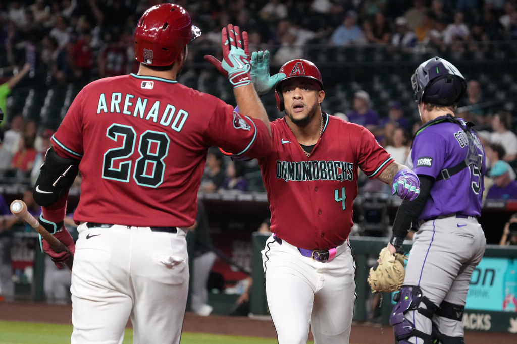Arizona Diamondbacks' Ketel Marte celebrates with Nolan Arenado (28) after hitting a solo home run against the Colorado Rockies in the first inning of a baseball game, Tuesday, Aug. 11, 2026, in Phoenix. (AP Photo/Rick Scuteri)