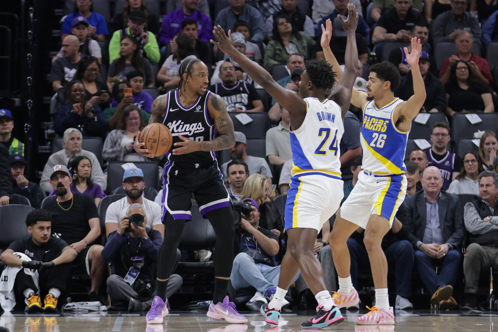 Sacramento Kings guard DeMar DeRozan (10) looks to pass as he is double teamed by Indiana Pacers guard Kobe Brown (24) and Indiana Pacers guard Ben Sheppard (26) during the first half of an NBA basketball game Tuesday, March 10, 2026, in Sacramento, Calif. (AP Photo/Scott Marshall)