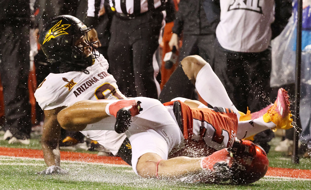 Utah cornerback Smith Snowden, right, tackles Arizona wide receiver Jordyn Tyson during the first half of an NCAA college football game Saturday, Oct. 11, 2025, in Salt Lake City, Utah. (AP Photo/Jeffrey D. Allred)