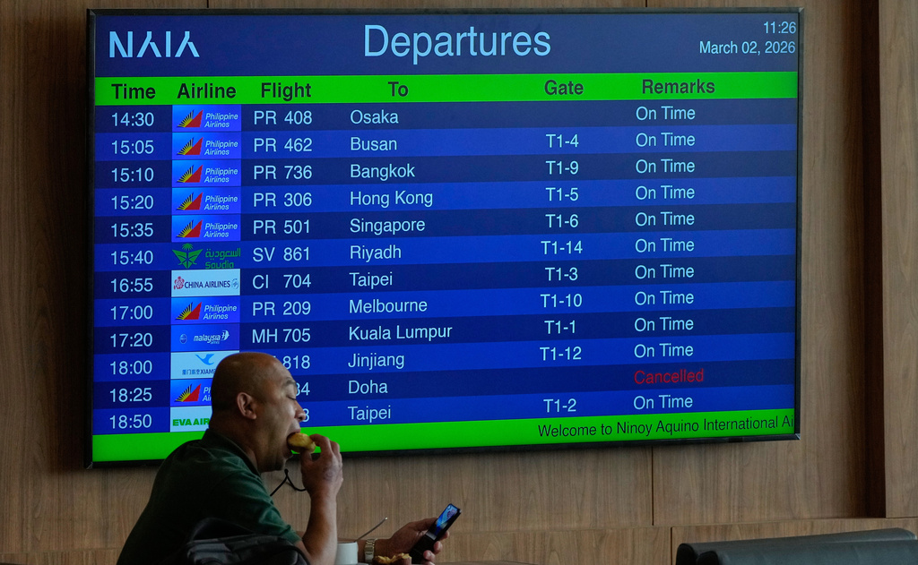 A board shows flight details at the Overseas Filipino Workers lounge at Manila's International Airport, Philippines on Monday, March 2, 2026. (AP Photo/Aaron Favila)