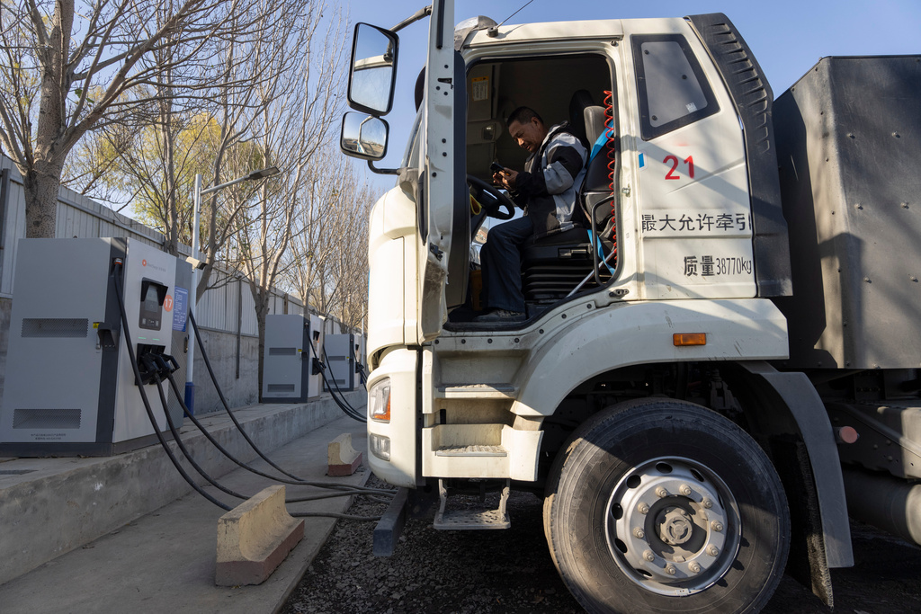 A driver sits in his electric truck at a charging station on the outskirts of Beijing, on Nov. 14, 2025. (AP Photo/Ng Han Guan)