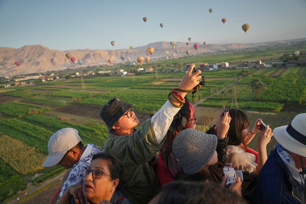 Chinese tourists film during their tour on a hot air balloon on the west bank of the Nile River in Luxor, Egypt, Oct. 4, 2025. (AP Photo/Amr Nabil)