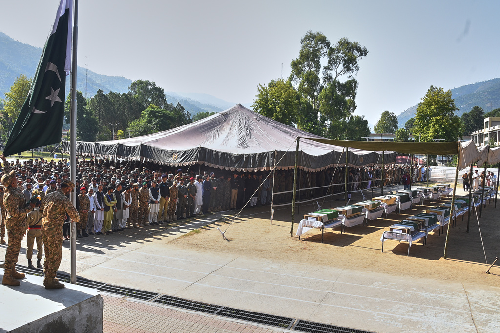 Military officers and civilians attend the funeral prayers of military personnel, killed in Wednesday's helicopter crash, during a funeral prayer, in Muzaffarabad, the capital of Pakistan-administered Kashmir, Thursday, June 11, 2026. (AP Photo/M.D. Mughal)