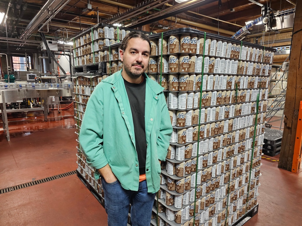 Ryan Bandy, chief business officer at Indeed Brewing in Minneapolis, stands near a pallet of six-packs of seltzer containing THC, the active ingredient in marijuana, in his brewery on Thursday, Nov. 20, 2025. (AP Photo/Steve Karnowski)