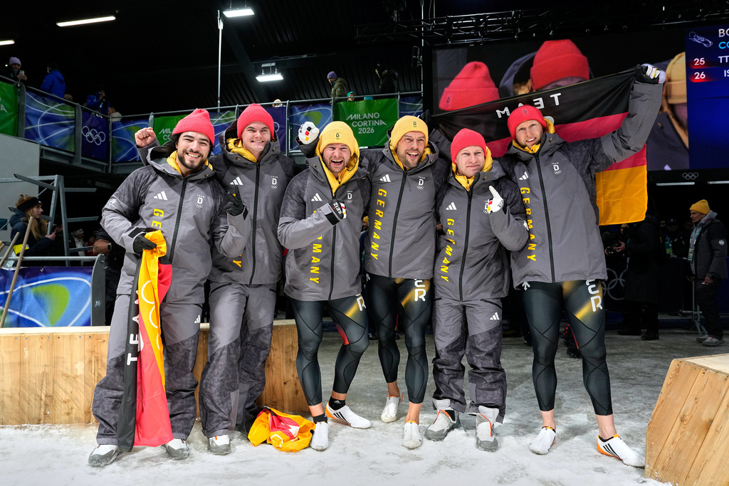 From left, Germany's bronze medalists Adam Ammour and Alexander Schaller, Germany's gold medalists Johannes Lochner and Georg Fleischhauer and Germany's silver medalists Francesco Friedrich and Alexander Schuller celebrate at the finish after the two man bobsled competition at the 2026 Winter Olympics, in Cortina d'Ampezzo, Italy, Tuesday, Feb. 17, 2026. (AP Photo/Alessandra Tarantino)