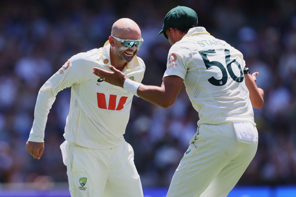 Australia's Nathan Lyon, left, celebrates with teammate Mitchell Starc after dismissing England's Ben Duckett during play on day two of the third Ashes cricket test between England and Australia in Adelaide, Australia, Thursday, Dec. 18, 2025. (AP Photo/James Elsby)