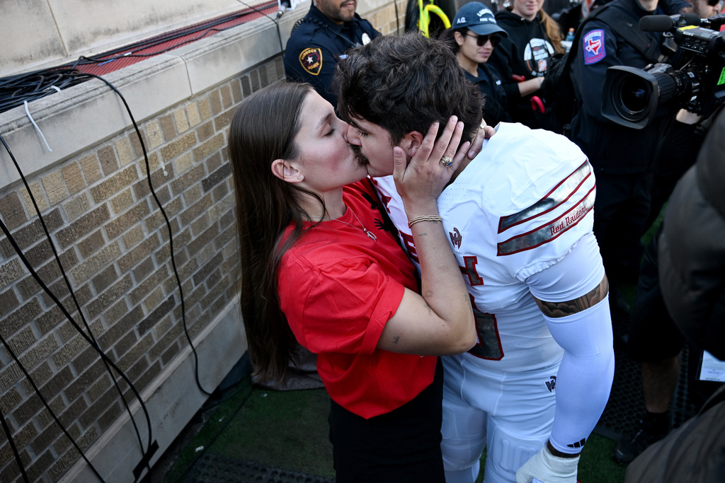 Emma Rodriguez, left, kisses her husband, Texas Tech linebacker Jacob Rodriguez, before the NCAA college football game between Texas Tech and BYU, Saturday, Nov. 8, 2025, in Lubbock, Texas. (AP Photo/Annie Rice)