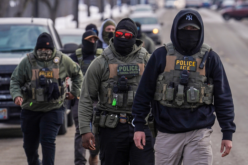 FILE - Federal agents walk down a street while conducting immigration enforcement operations in Minneapolis, Feb. 5, 2026. (AP Photo/Ryan Murphy, File)