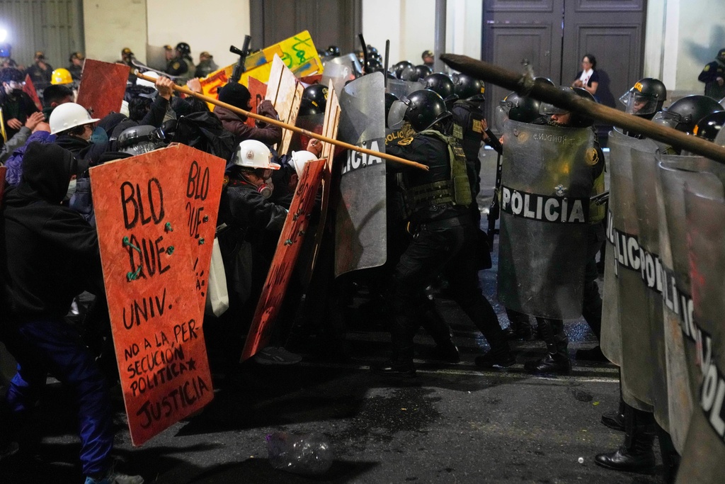 Demonstrators clash with riot police near Congress during a protest against new President Jose Jeri in Lima, Peru, Wednesday, Oct. 15, 2025. (AP Photo/Martin Mejia)