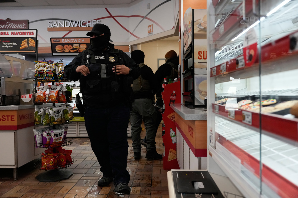 ICE agents make use of the facilities at a gas station, Monday, Jan. 19, 2026, in St. Paul, Minn. (AP Photo/Yuki Iwamura)