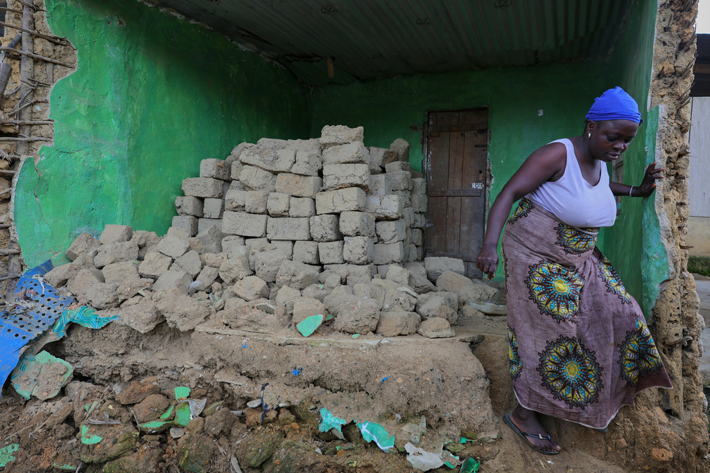 Hawa Manubah, a mother of 13, leaves the ruins of her former home, which she says was damaged by concussions from mining explosives, in Gold Camp, Liberia. "We were in the house when we heard the blasting sound-boom, and everyone ran away," she said on July 8, 2025. (AP Photo/Misper Apawu)
