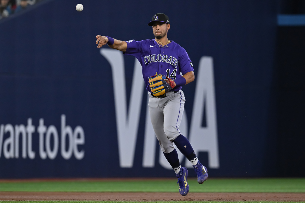 Colorado Rockies infielder Ezequiel Tovar throws to first base to put out Toronto Blue Jays catcher Alejandro Kirk in second-inning baseball game action in Toronto, Monday, March 30, 2026. (Jon Blacker/The Canadian Press via AP)