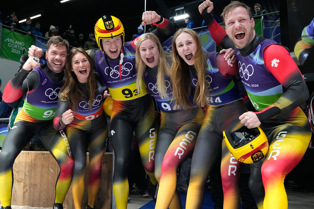 Germany's gold medalists Tobias Wendl, Tobias Arlt, Max Langenhan, Julia Taubitz, Dajana Eitberger and Magdalena Matschina celebrate after the luge relay competition at the 2026 Winter Olympics, in Cortina d'Ampezzo, Italy, Thursday, Feb. 12, 2026. (AP Photo/Alessandra Tarantino)