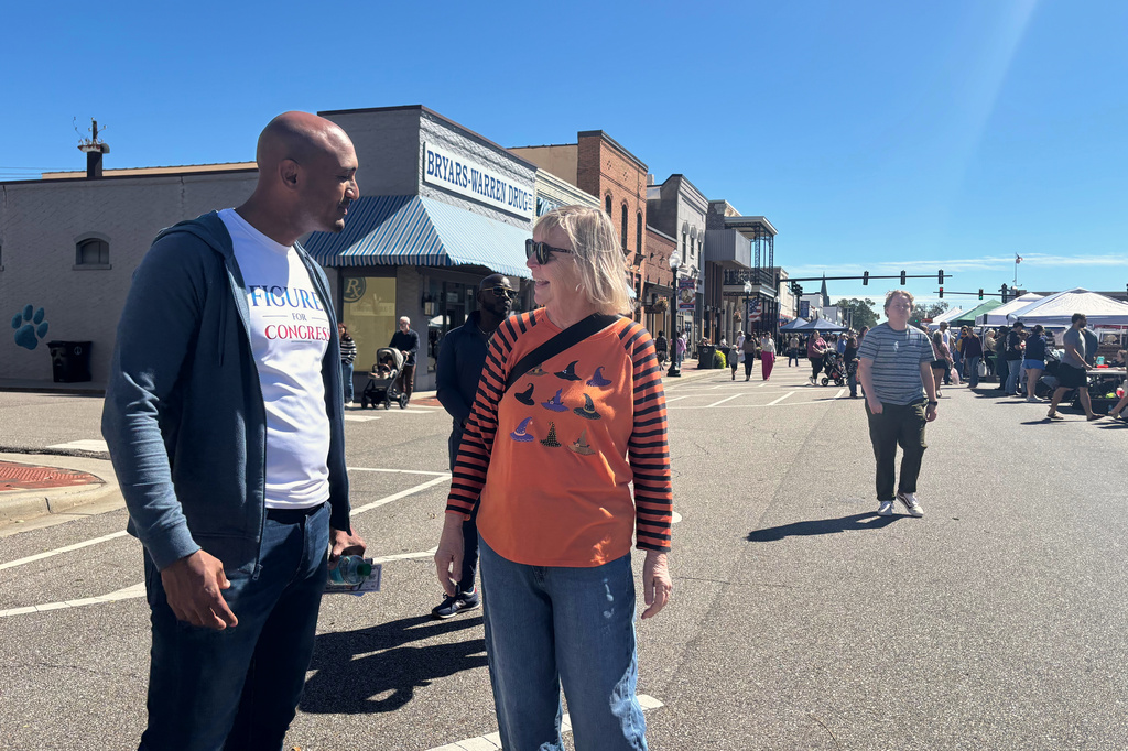 In this photo taken with a smartphone Rep. Shomari Figures, D-Ala., speaks to Jo Ellen Simmons at the Boll Weevil festival in Enterprise, Ala., on Saturday, Oct. 17, 2026. (AP Photo/Kim Chandler)