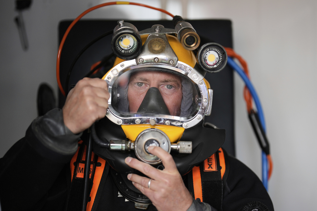 A diver checks his equipment during a press tour to show the recovering of ammunition from World War II in the Baltic Sea near Boltenhagen, Germany, Monday, Sept. 1, 2025. (AP Photo/Markus Schreiber)