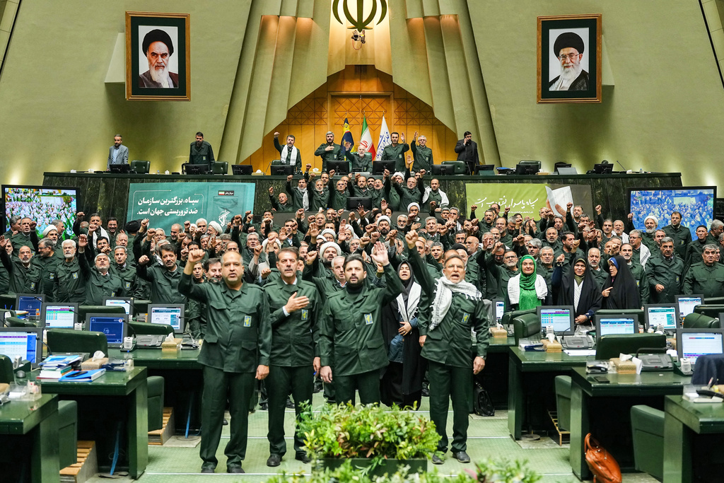In this handout photo released by the Islamic Consultative Assembly News Agency (ICANA) Iranian lawmakers chant slogans as they wear the Revolutionary Guard's uniform in a session of parliament, in Tehran, Iran, Sunday, Feb. 1, 2026. (Hamed Malekpour/ICANA via AP)