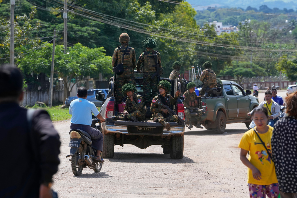 In this photo taken during a trip supervised by pro-military Myanmar media, soldiers patrol a road in Kyaukme, northern Shan State, Myanmar, Friday, Oct. 10, 2025. (AP Photo/Aung Shine Oo)