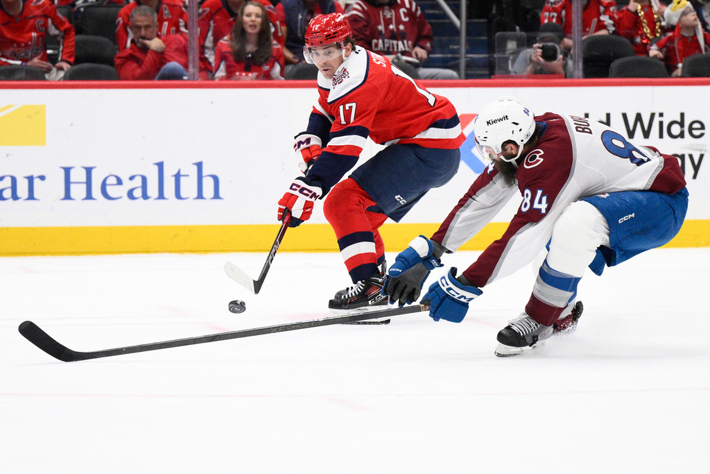 Washington Capitals center Dylan Strome (17) passes the puck against Colorado Avalanche defenseman Brent Burns (84) during the first period of an NHL hockey game, Sunday, March 22, 2026, in Washington. (AP Photo/Nick Wass)