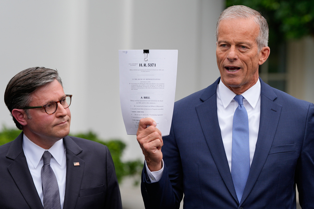 Senate Majority Leader John Thune, R-S.D., talks to reporters outside the West Wing of the White House, Monday, Sept. 29, 2025, in Washington, as House Speaker Mike Johnson of La., listens. (AP Photo/Alex Brandon)
