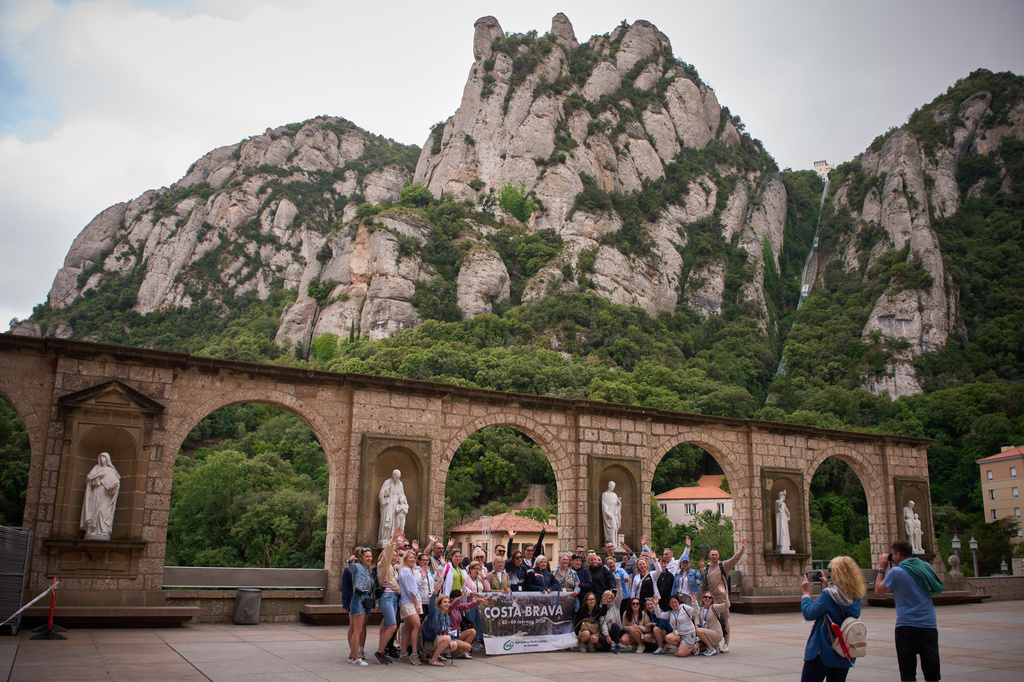 Tourists pose for a photo at the main square of the Monastery of Montserrat near Barcelona, Spain, Friday, June 5, 2026. (AP Photo/Emilio Morenatti)