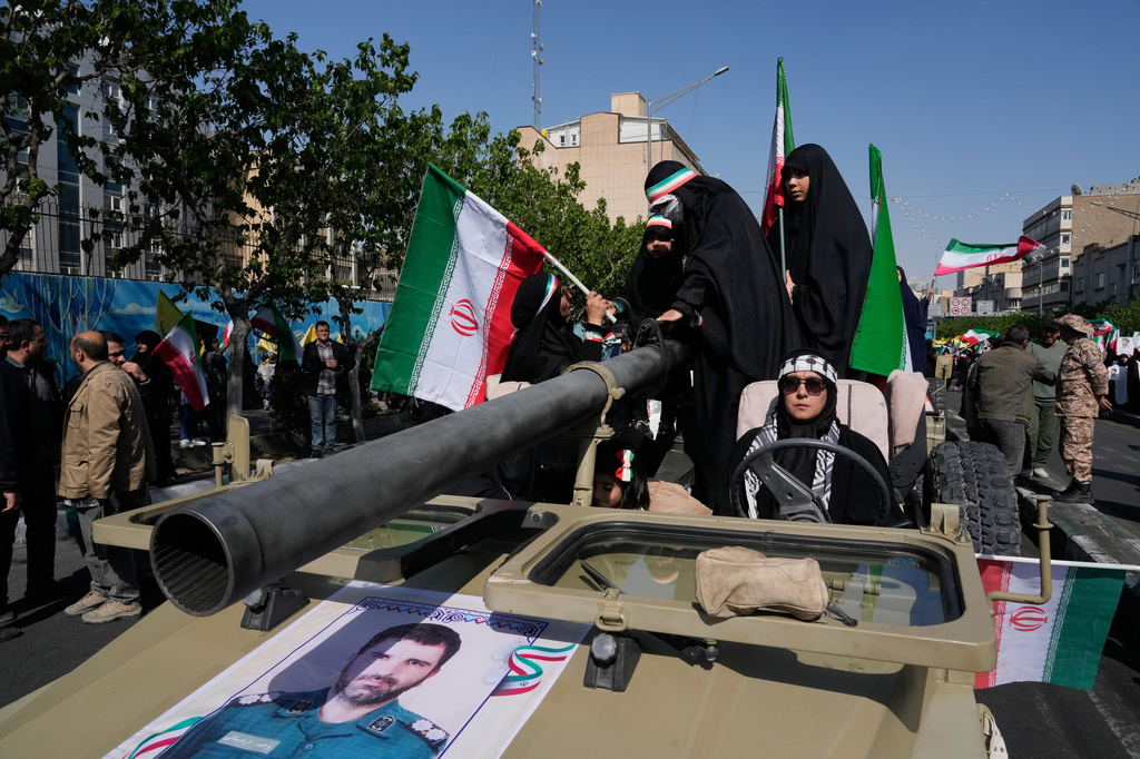 FILE - Women members of the Basij paramilitary, affiliated with Iran's Revolutionary Guard, march with their weapons during a state-organized rally in support of the supreme leader marking National Girl's Day, in Tehran, Iran, Friday, April 17, 2026. (AP Photo/Vahid Salemi, File)