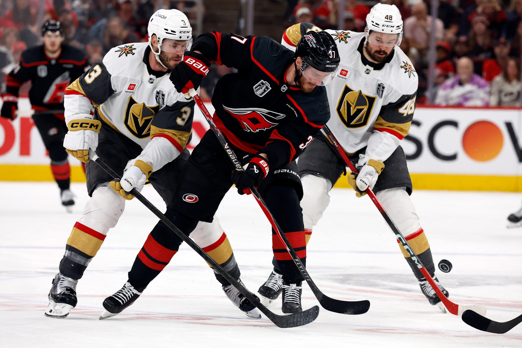 Carolina Hurricanes' Andrei Svechnikov (37) battles for the puck between Vegas Golden Knights' Brayden McNabb (3) and Tomas Hertl (48) during the second period in Game 1 of the NHL hockey Stanley Cup Final series in Raleigh, N.C., Tuesday, June 2, 2026. (AP Photo/Karl DeBlaker)