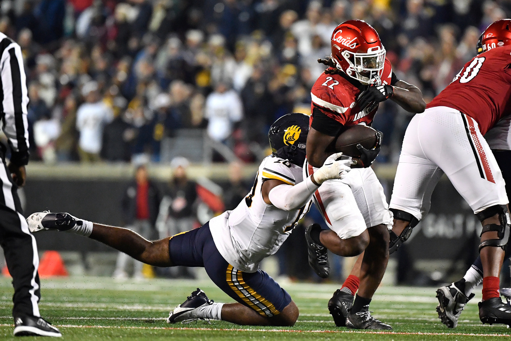 California linebacker Jayden Wayne, left, attempts to tackle Louisville running back Keyjuan Brown (22) during overtime of an NCAA college football game in Louisville, Ky., Saturday, Nov. 8, 2025. (AP Photo/Timothy D. Easley)