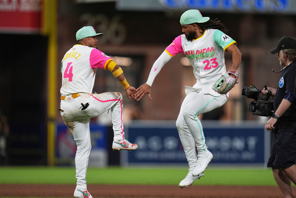 San Diego Padres right fielder Fernando Tatis Jr. (23) celebrates with first baseman Luis Arraez (4) after the Padres defeated the Arizona Diamondbacks 7-4 in a baseball game Friday, Sept. 26, 2025, in San Diego. (AP Photo/Gregory Bull)