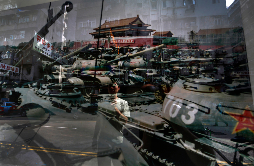 FILE - A man looks at a photo, believed to be taken by a former People's Liberation Army soldier during Beijing's June 4, 1989 Chinese military crackdown on the pro-democracy movement displayed in Hong Kong on June 4, 2012. (AP Photo/Vincent Yu, File)
