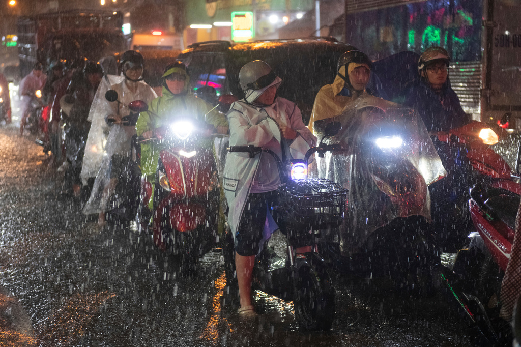 People ride motorbikes through floodwater caused by rain and high tide, on Pham Huu Lau Street in Ho Chi Minh City, Vietnam, Wednesday, Sept. 30, 2026. (AP Photo/Thanh Hue)