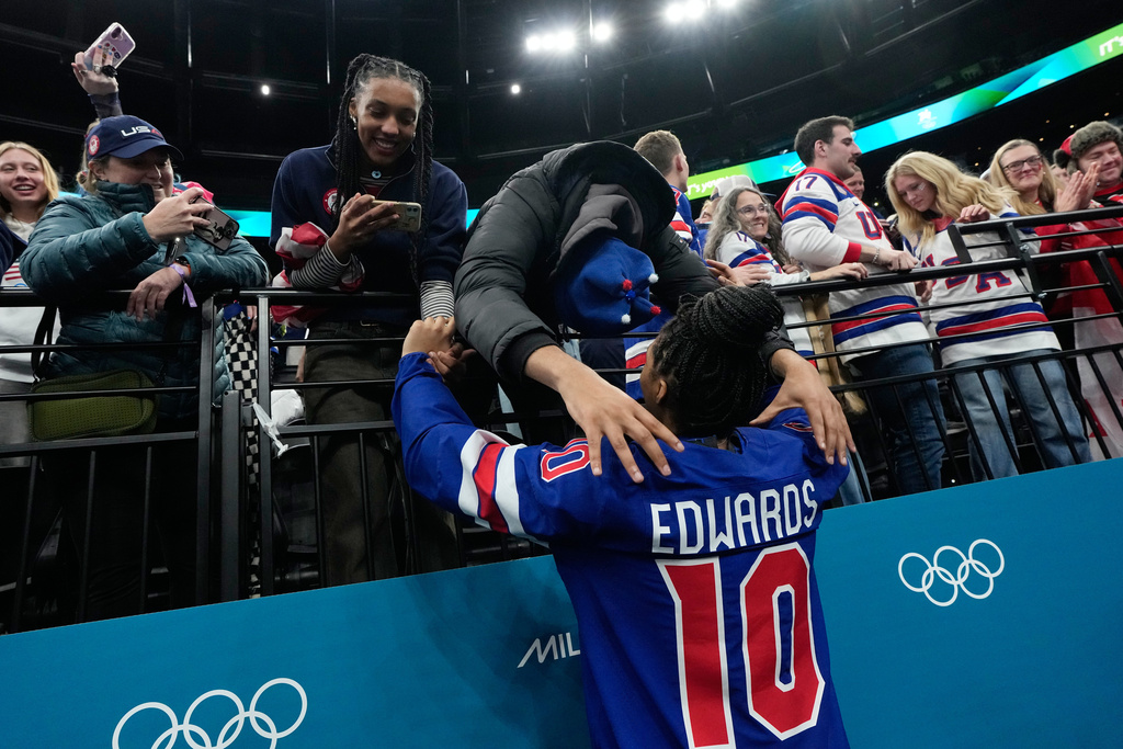 United States' Laila Edwards (10) gets a hug after United States' women's ice hockey team was presented with the gold medals at the 2026 Winter Olympics, in Milan, Italy, Thursday, Feb. 19, 2026. (AP Photo/Petr David Josek)