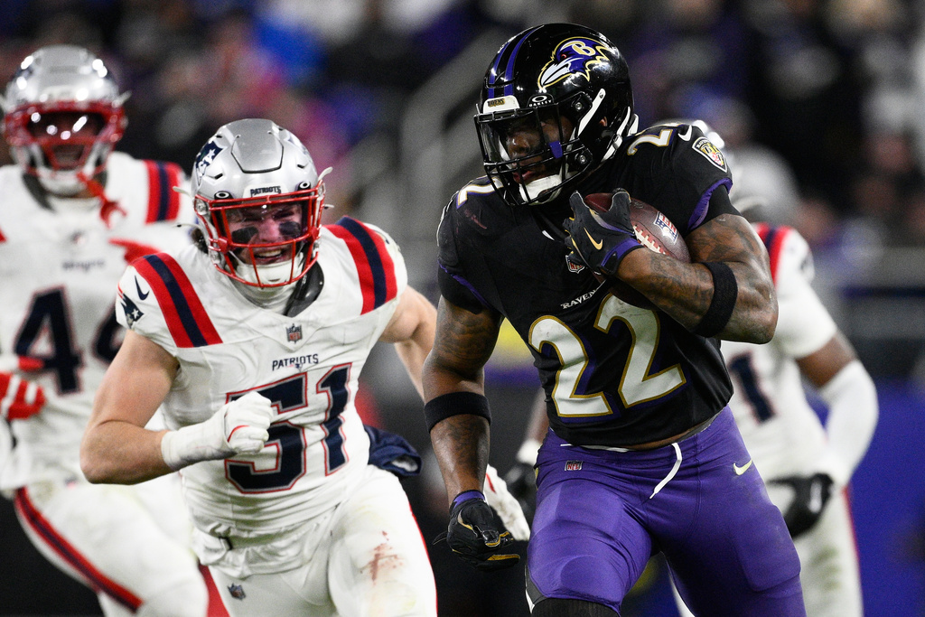 Baltimore Ravens running back Derrick Henry (22) runs against New England Patriots linebacker Jack Gibbens (51) during the second half of an NFL football game, Sunday, Dec. 21, 2025, in Baltimore. (AP Photo/Nick Wass)