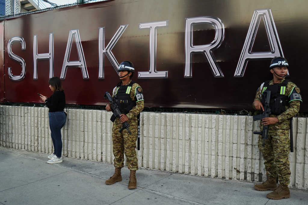 Soldiers stand in front of a sign for Colombian pop star Shakira before her concert at the National Stadium in San Salvador, El Salvador, Thursday, Feb. 12, 2026. (AP Photo/Salvador Melendez)