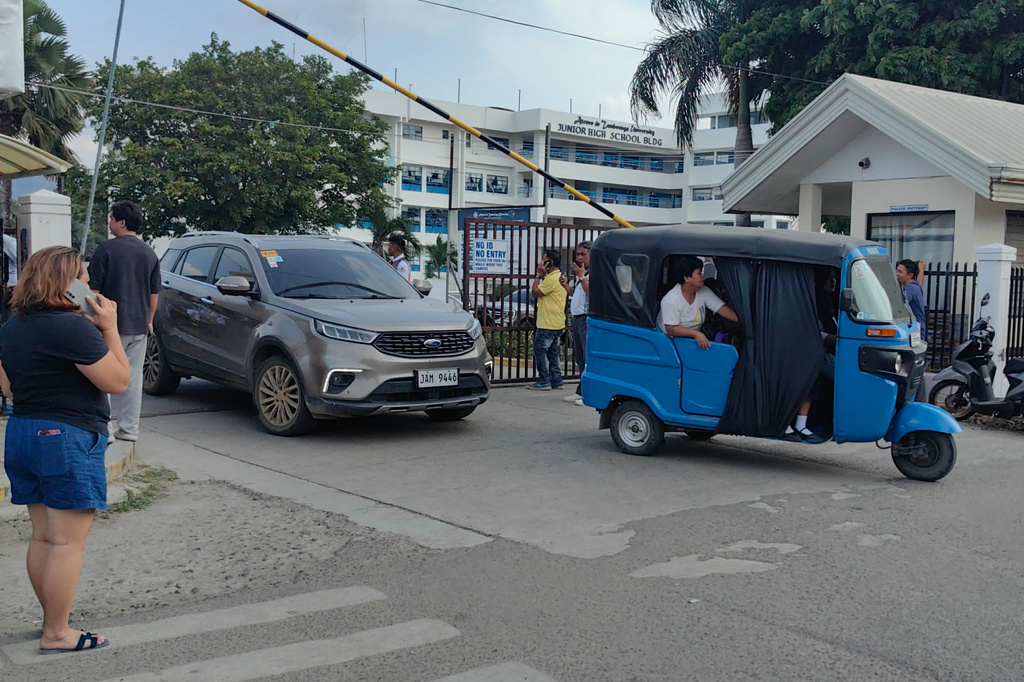 Vehicles exit the Ateneo de Zamboanga University following a shooting incident in Zamboanga, southern Philippines Tuesday, Aug. 18, 2026. (AP Photo) CORRECTION: Corrects date and day