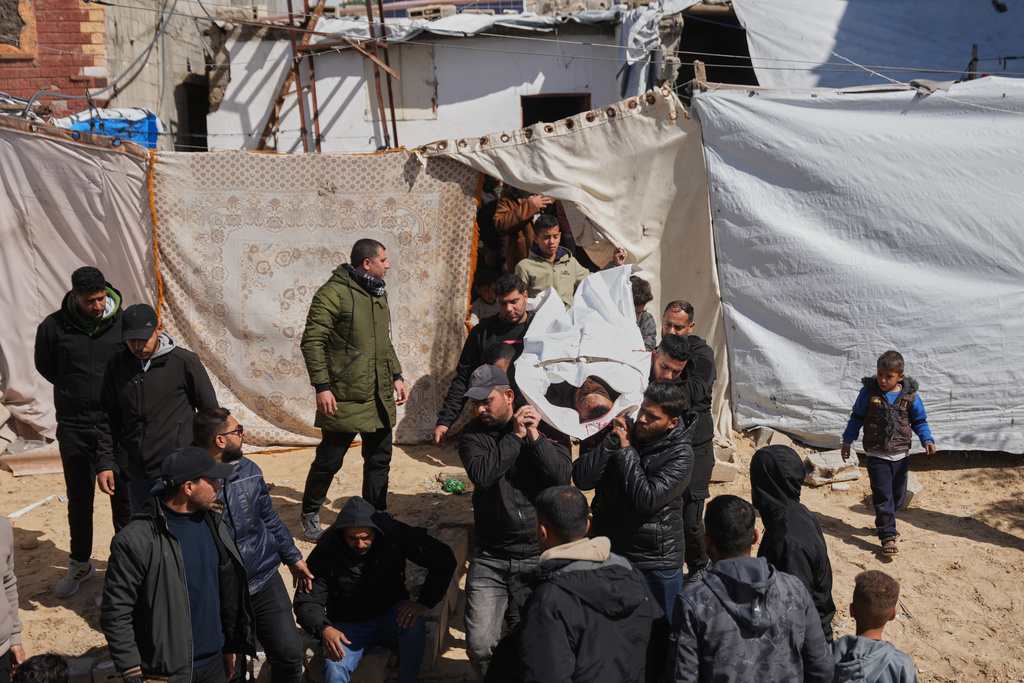 Mourners carry the body of the Palestinian policeman, Khaled Al-Zayan, who was killed in an Israeli military strike, during his funeral in Khan Younis, southern Gaza Strip, Friday, Feb. 27, 2026. (AP Photo/Abdel Kareem Hana)